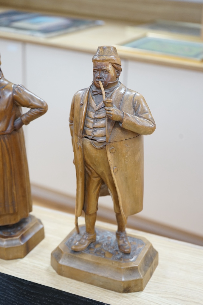 A pair of 19th century Black Forest figural tobacco jars, one of a gentleman with a stick smoking a pipe, the other of a lady holding an umbrella, gentleman 35cm high. Condition - damage to gents front waitcoat, back bow